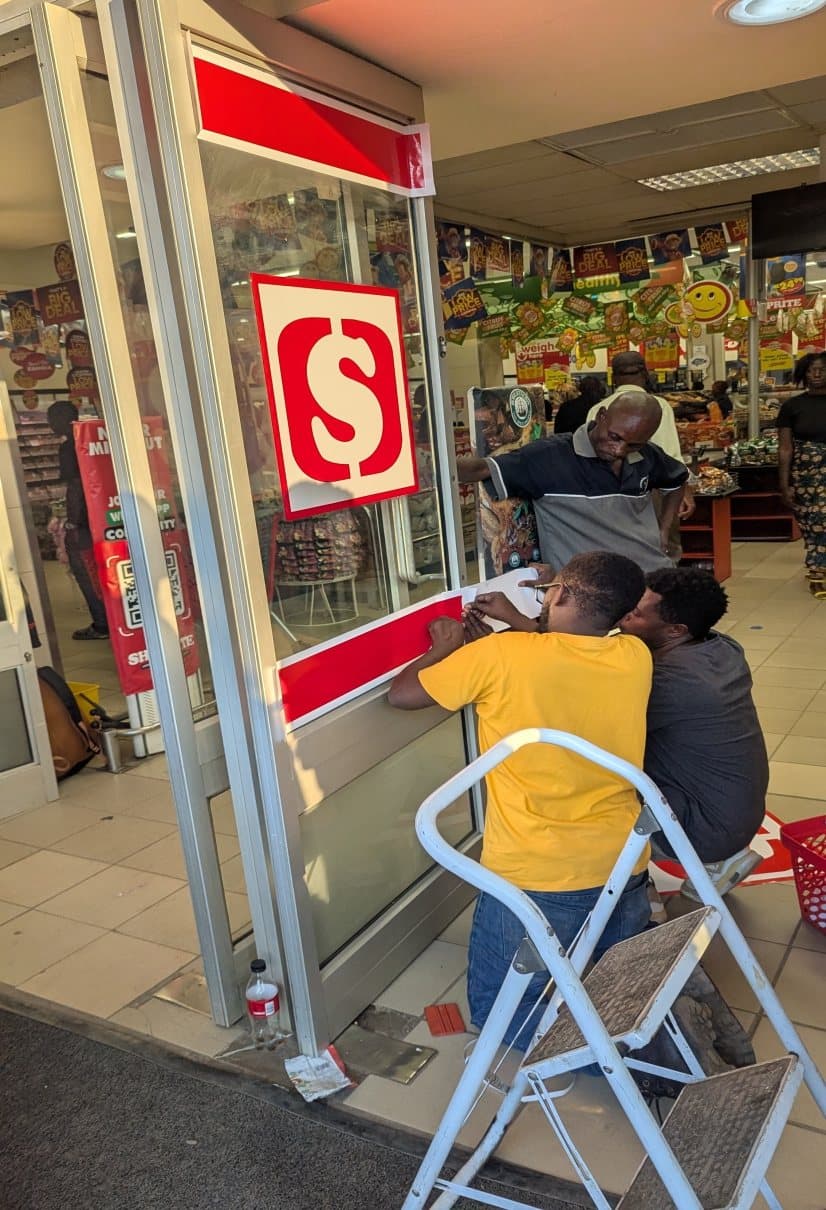 Entrance signage being fitted at a Shoprite store